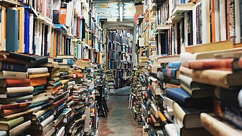 Bild: Bücherregale und Bücherstapel
