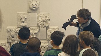 Bild: Mann mit Fledermaus zeigt Kindern Wasserspeier im kontiki