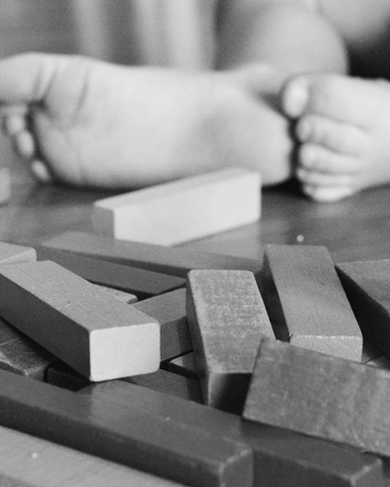 Ein Kind spielt mit Holzklötzen. Bild: Ein Kind spielt mit Holzklötzen.