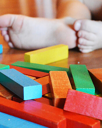 Bild: Ein Kind spielt mit Holzklötzen.
