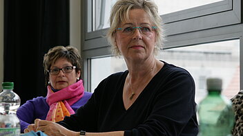 Eine Frau hört gespannt im Unterricht zu