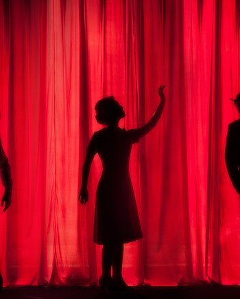 Theatervorhang mit Silhouetten dreier Schauspieler