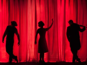 Theatervorhang mit Silhouetten dreier Schauspieler