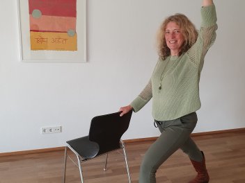 Person macht Yoga mit dem Stuhl